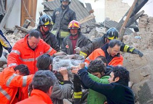 Italian rescue teams retrieve a person from a building which collapsed following an earthquake